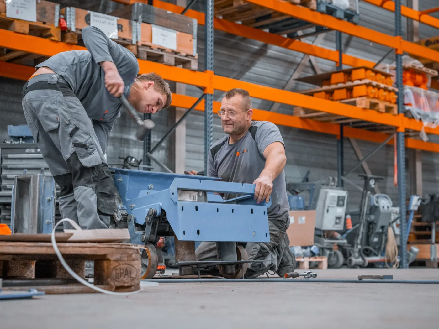 Twee monteurs van LOUER bouwen samen aan een machine in de werkplaats